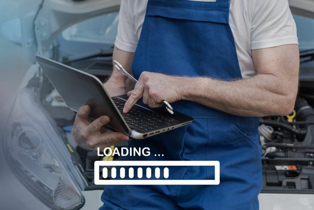 loading screen on a slow piece of business software. an impatient mechanic looks at his screen waiting for it to finish.