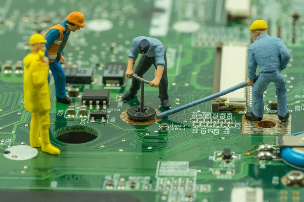 Miniature workers installing hardware into a computer motherboard