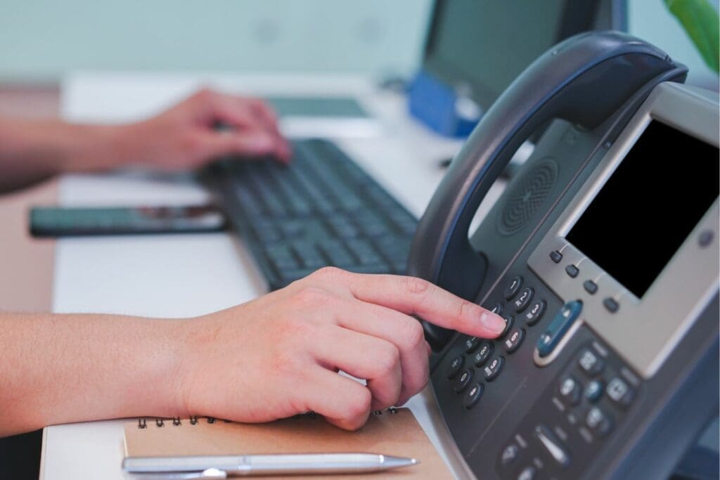 Man using phone and computer at the same time to process orders