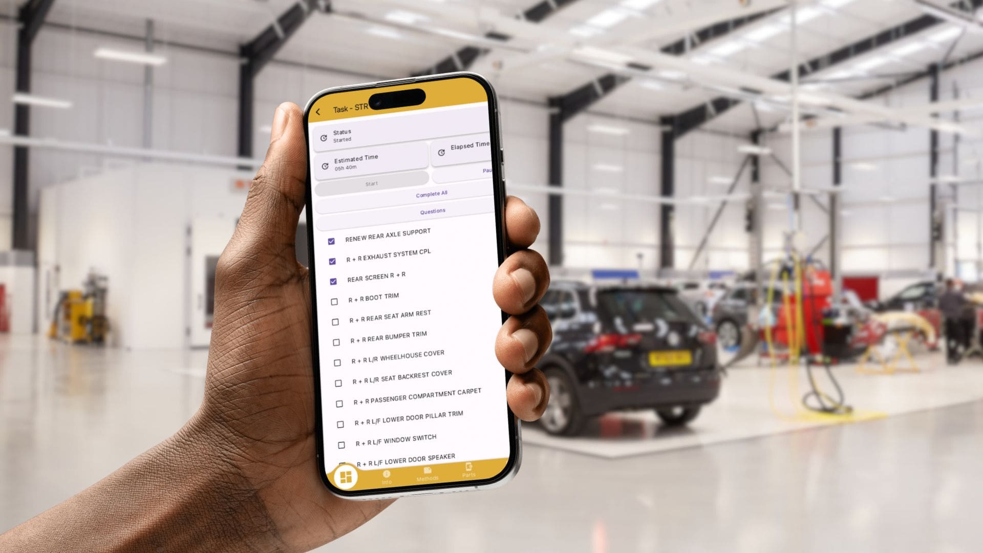 Bodyshop Technician using the Onyx BMS mobile app to manage tasks and priorities from the workshop floor.